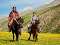 foreigner and tibetan nomad ride horses