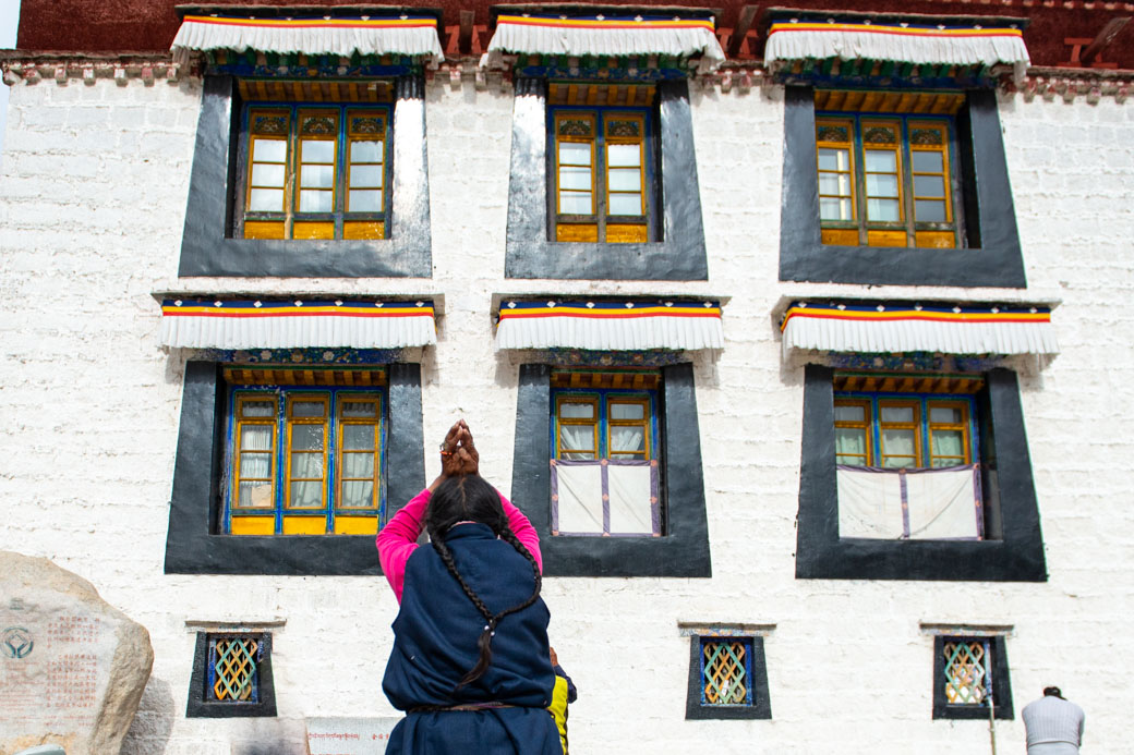 An old lady making a prostration towards Jokhang Temple in Lhasa. 
