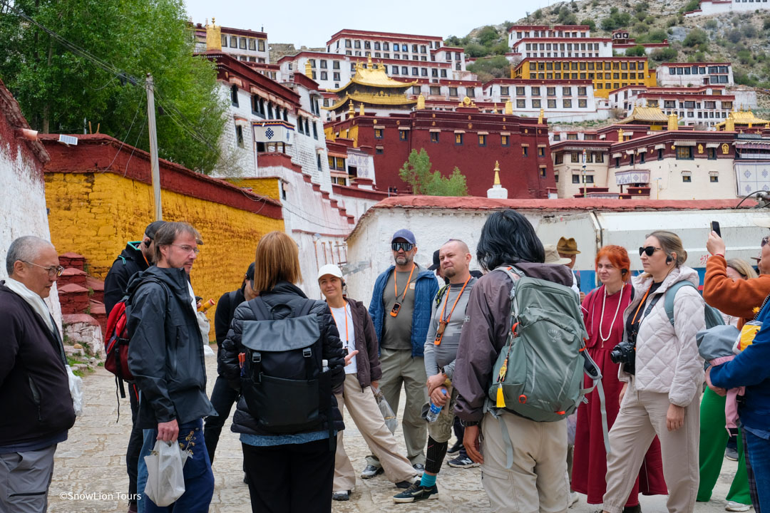 Our guide is leading a group to the Ganden Monastery in Tibet